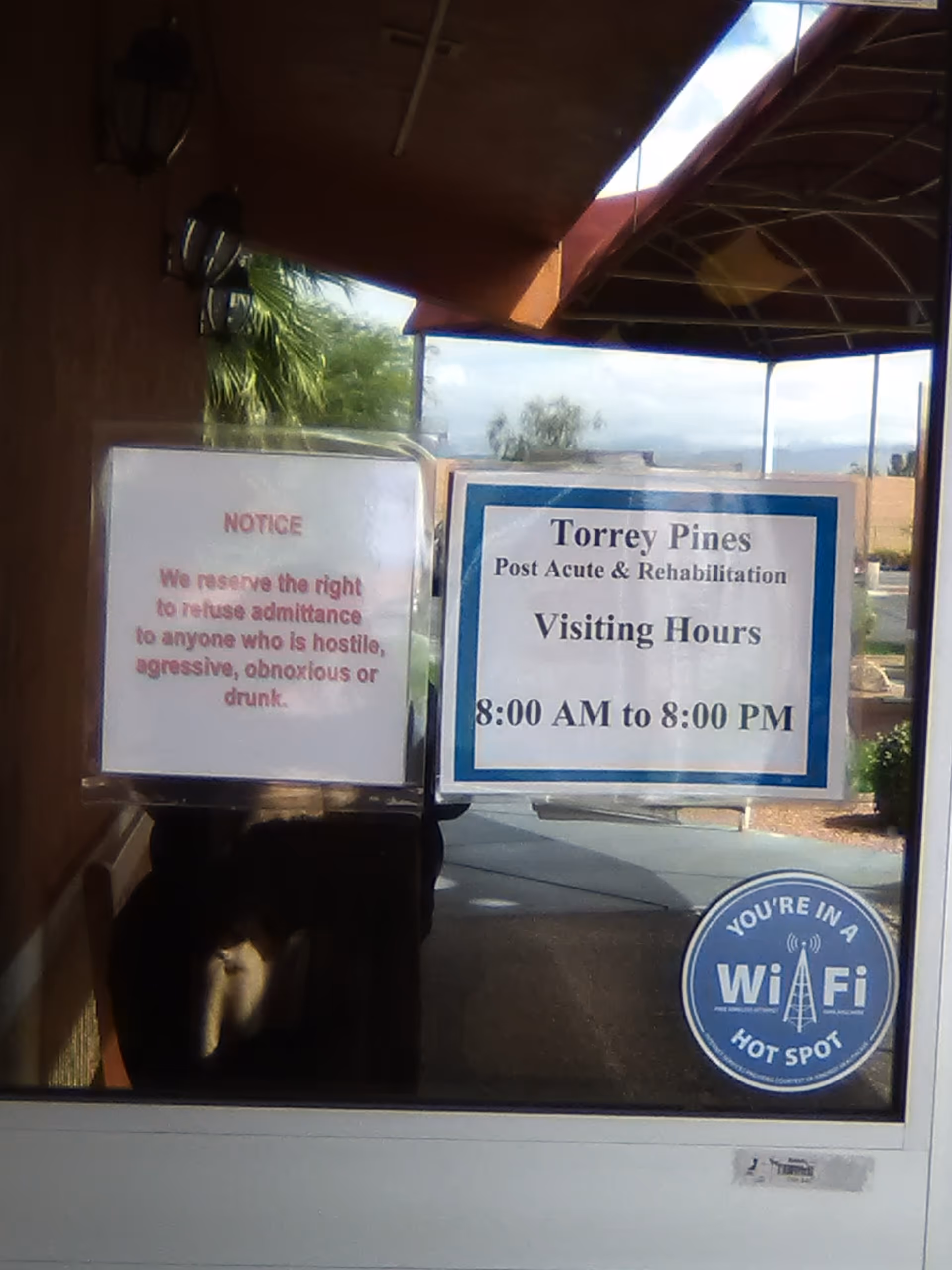 Entrance door with notices including Torrey Pines Visiting Hours and a WiFi sticker.