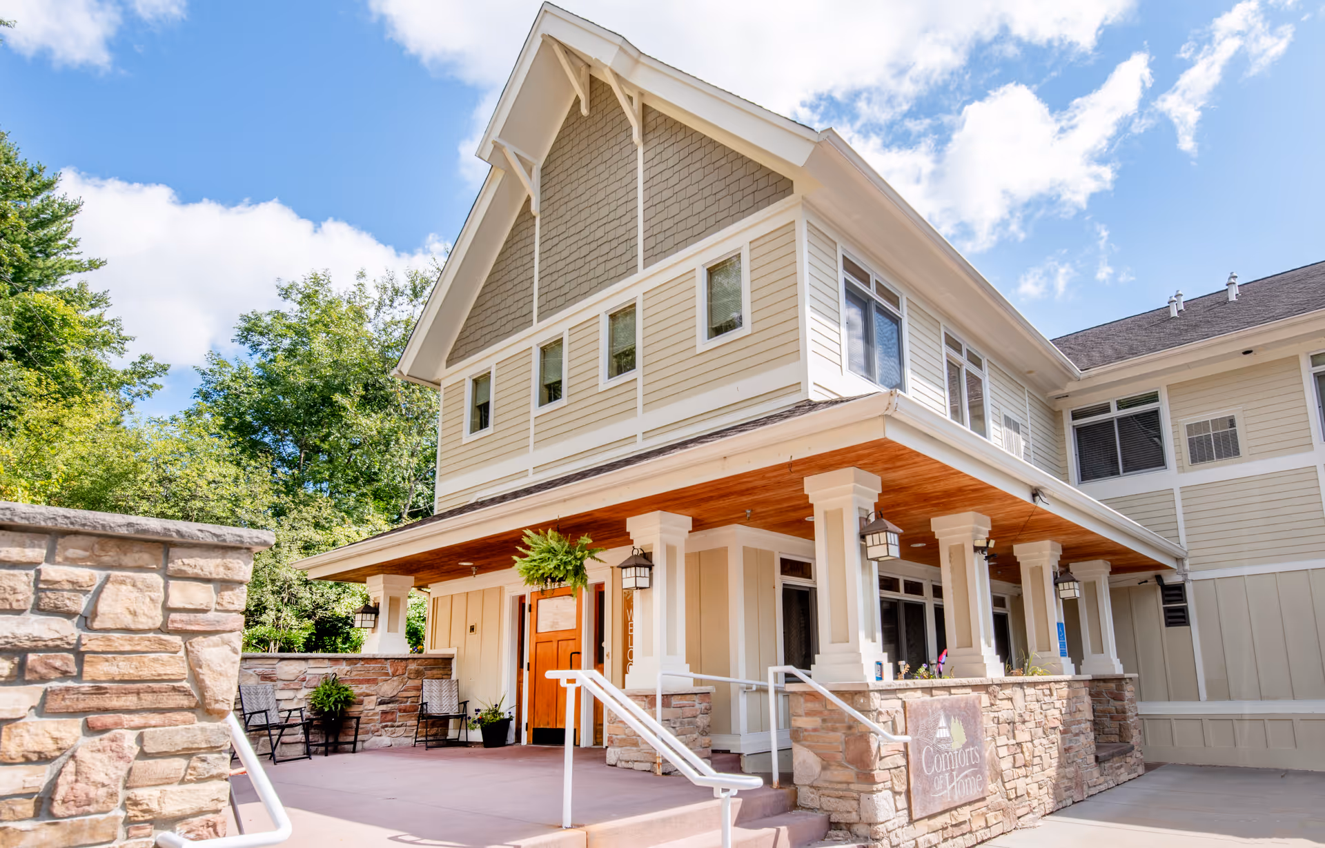 Two-story Comforts of Home Chippewa Falls exterior with porch and stone columns.