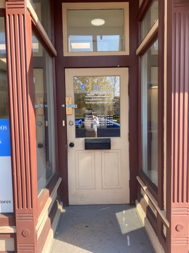 Entrance door for Marks Home Care Agency (Rochester) with windows and maroon trim.