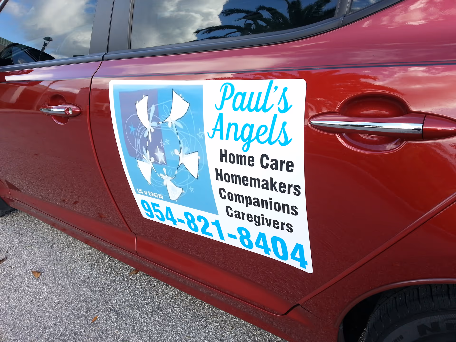 Red van with a large white and blue Paul's Angels Home Care sign on side.
