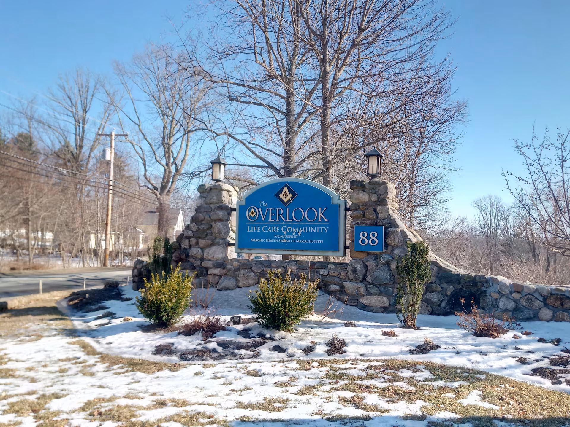Stone entrance sign reads The Overlook Life Care Community with 88, snow on ground.