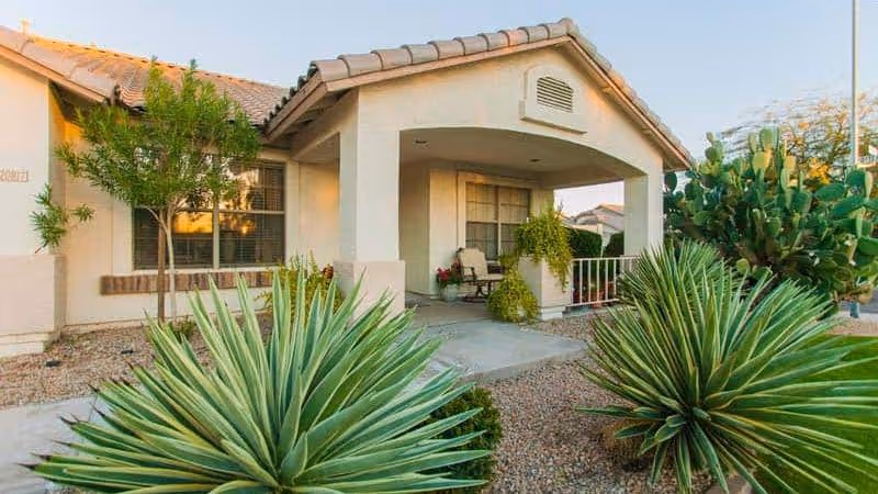 Exterior view of West Valley Care Home II entrance with desert landscaping.