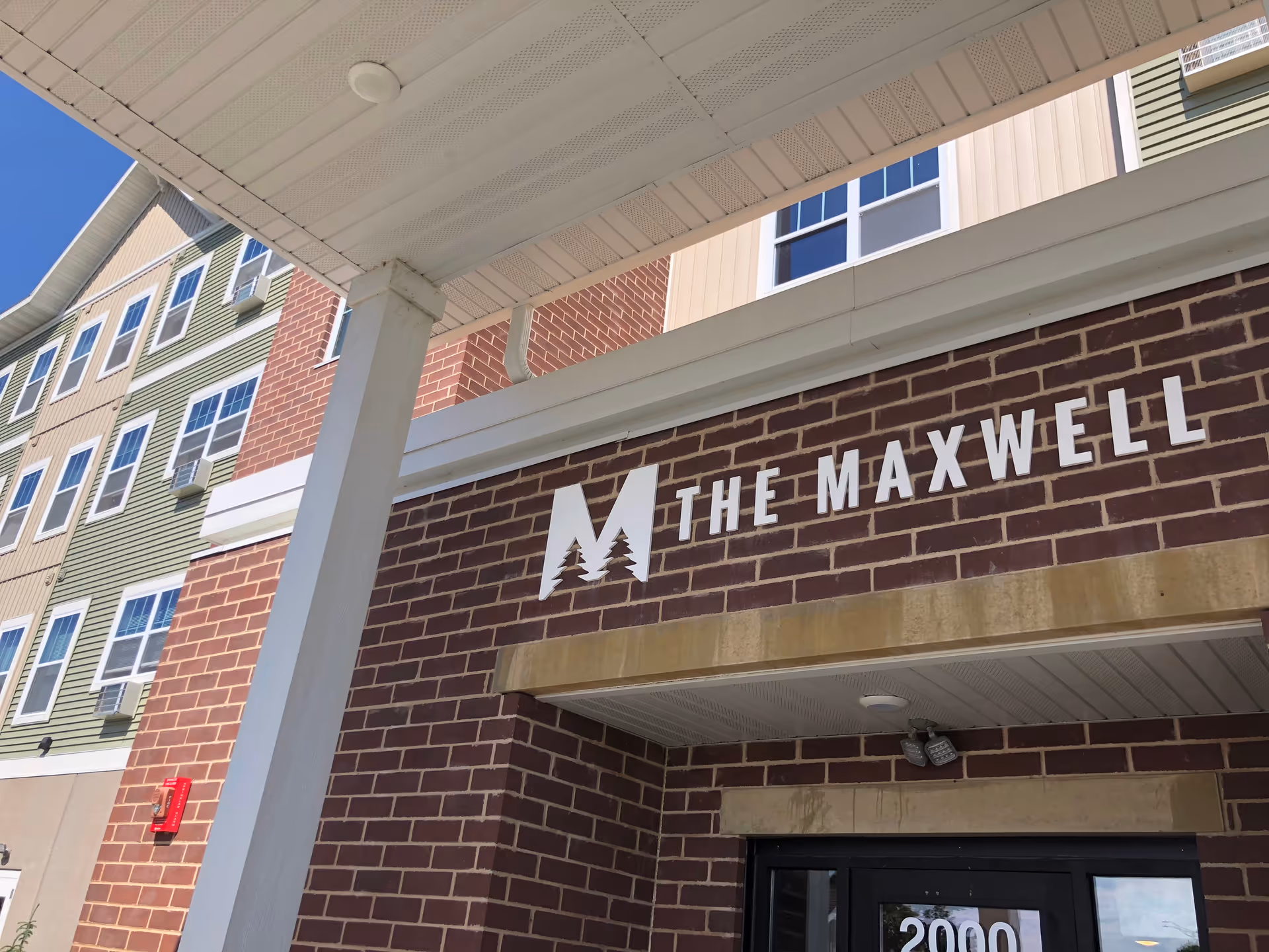 Exterior view of The Maxwell senior living facility entrance with brick facade.