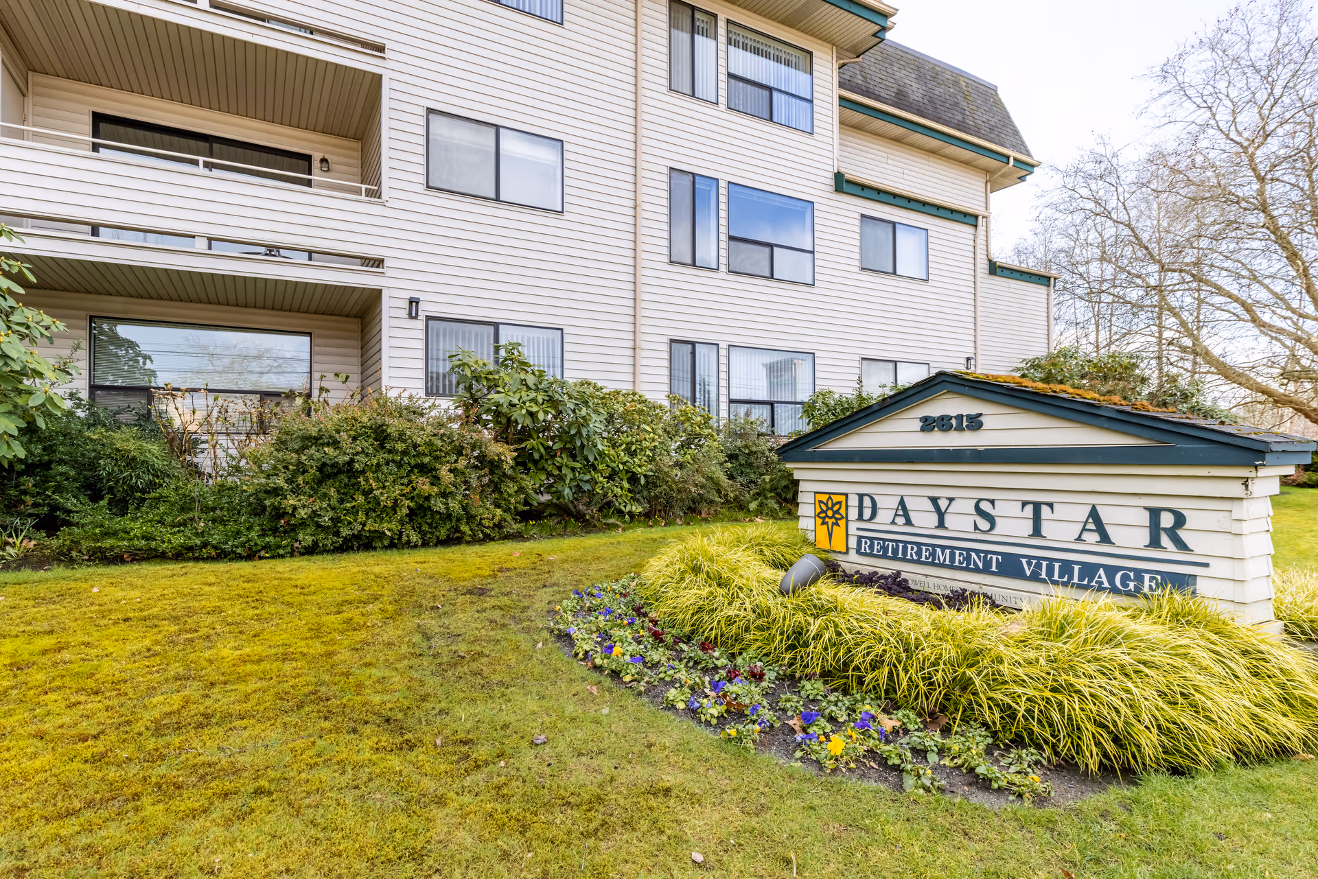 Exterior view of Daystar Retirement Village building with landscaped lawn and front sign.