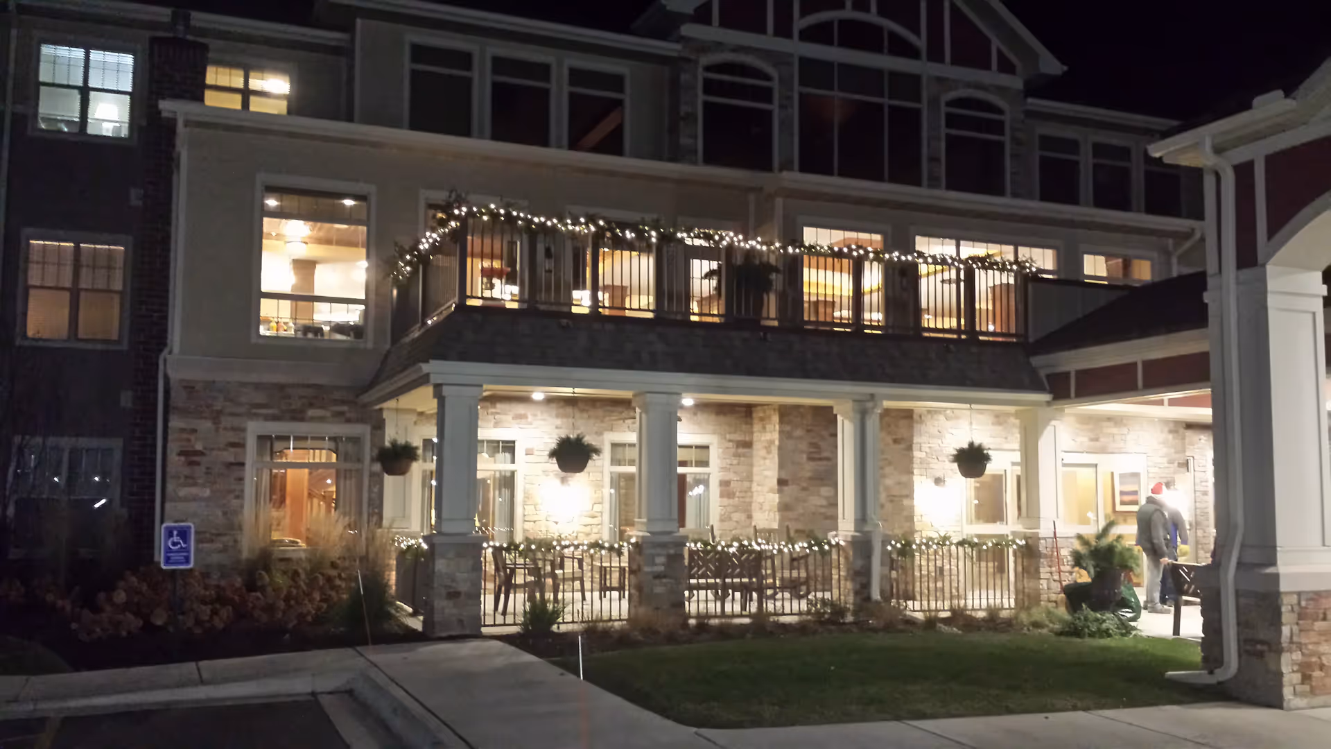 Night exterior view of New Perspective Senior Living Howard with lit entry and balcony lights.