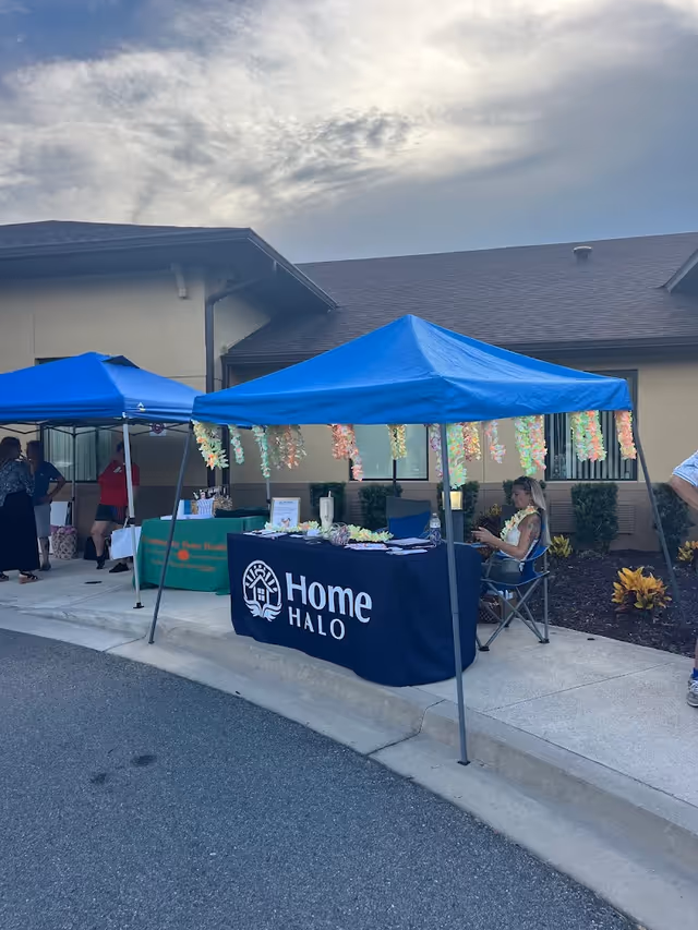 Blue tents set up outside Home Halo of Plano with a vendor table and decorations.