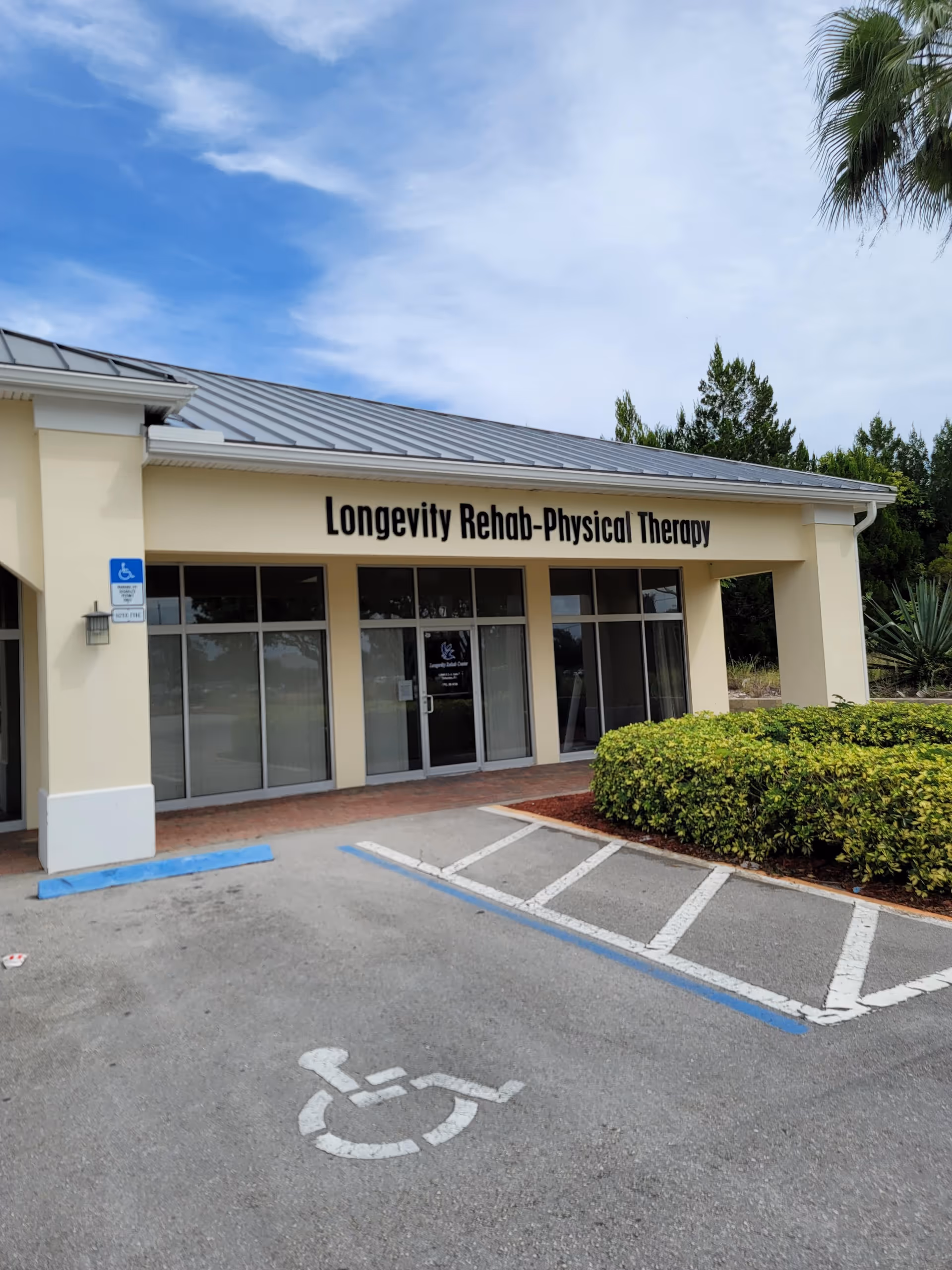 Exterior of Longevity Rehab-Physical Therapy with glass entry and handicap parking.
