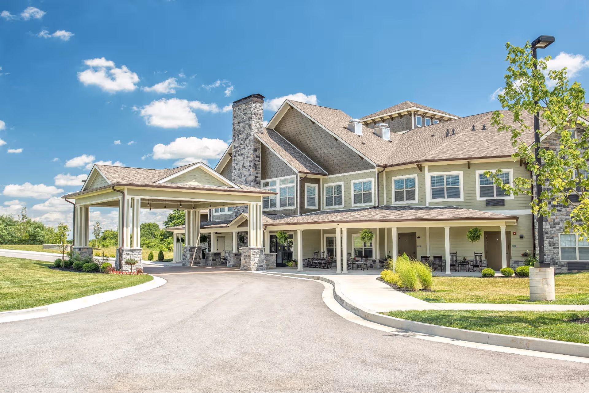 Exterior view of a senior living facility with covered entrance and driveway.