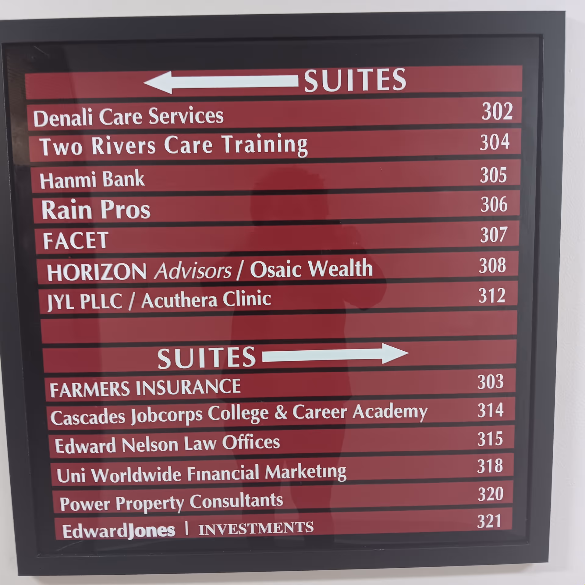 Maroon directory sign listing suites and tenants, including Two Rivers Care Training, inside a facility.
