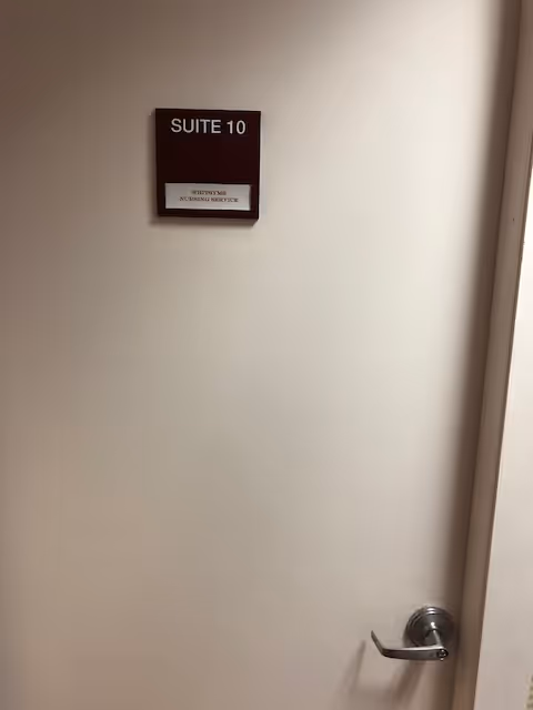 Plain beige interior door labeled Suite 10 in a dim hallway.