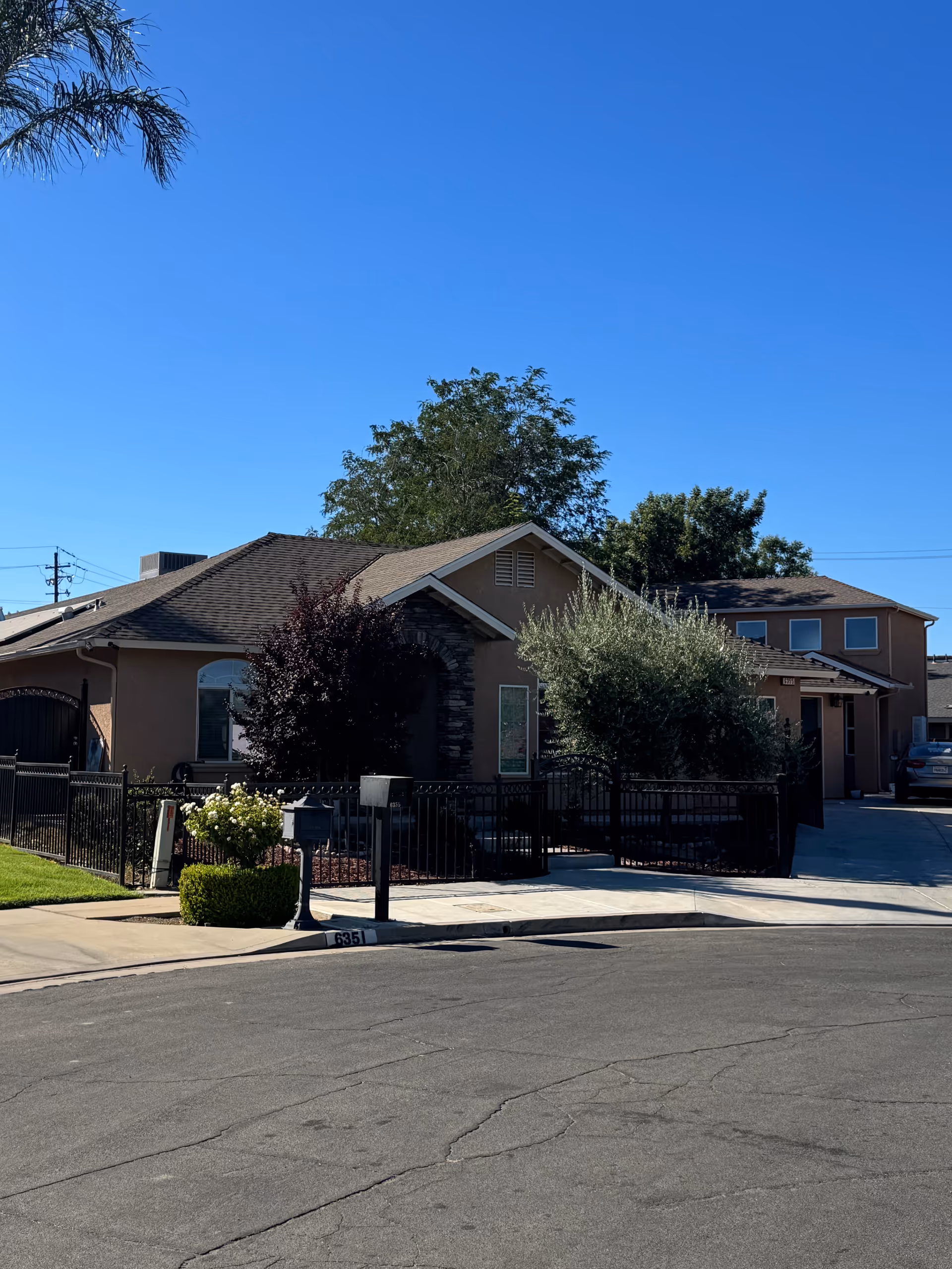 One-story assisted living facility exterior with a gated entrance and landscaping.