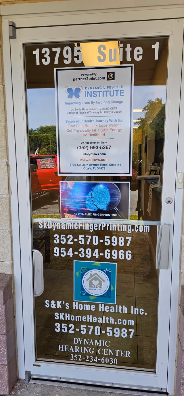 Glass front door covered in posters advertising SK Dynamic Fingerprinting and related services.
