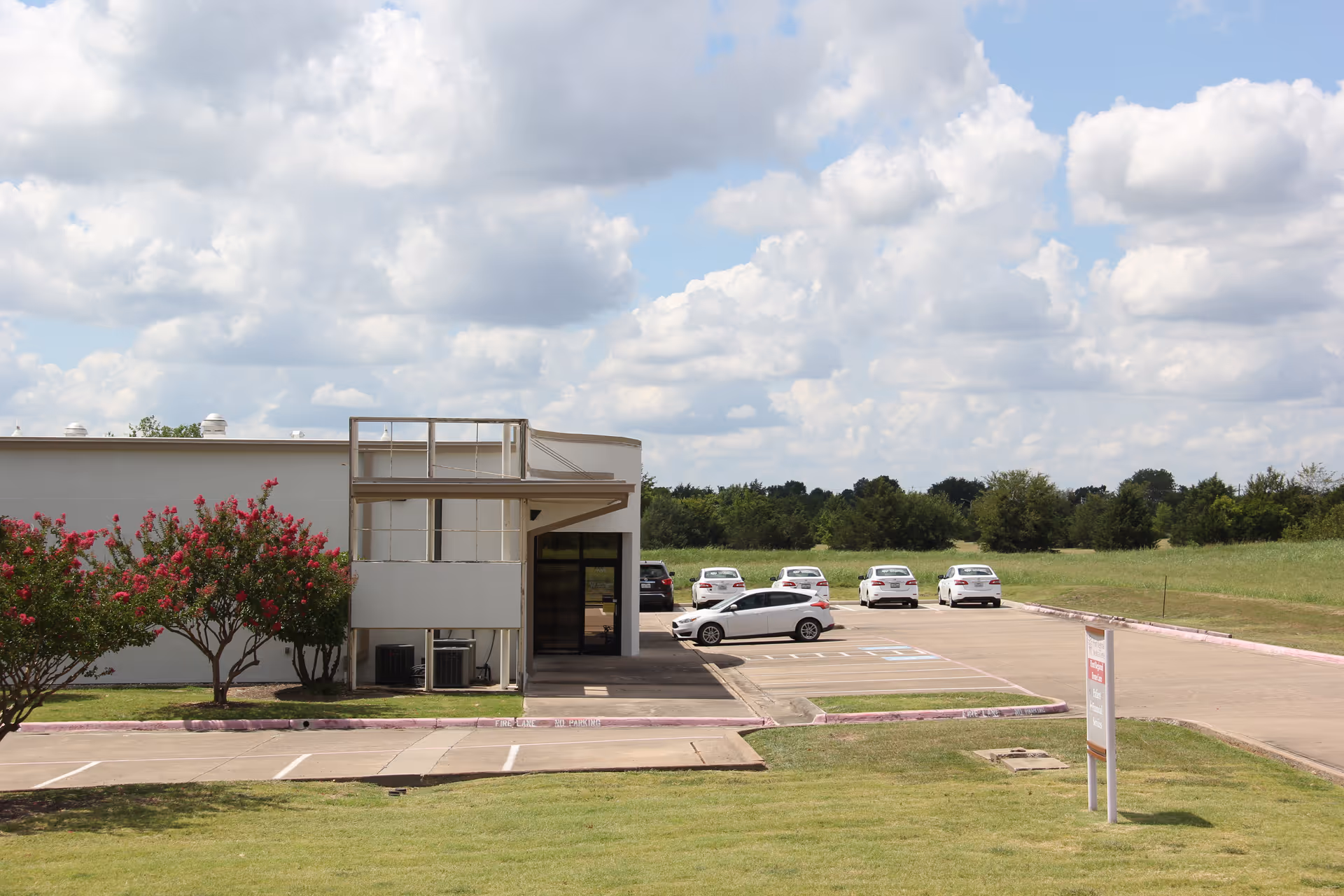 Exterior view of Hunt Regional Home Care with a parking lot and open grassy field.