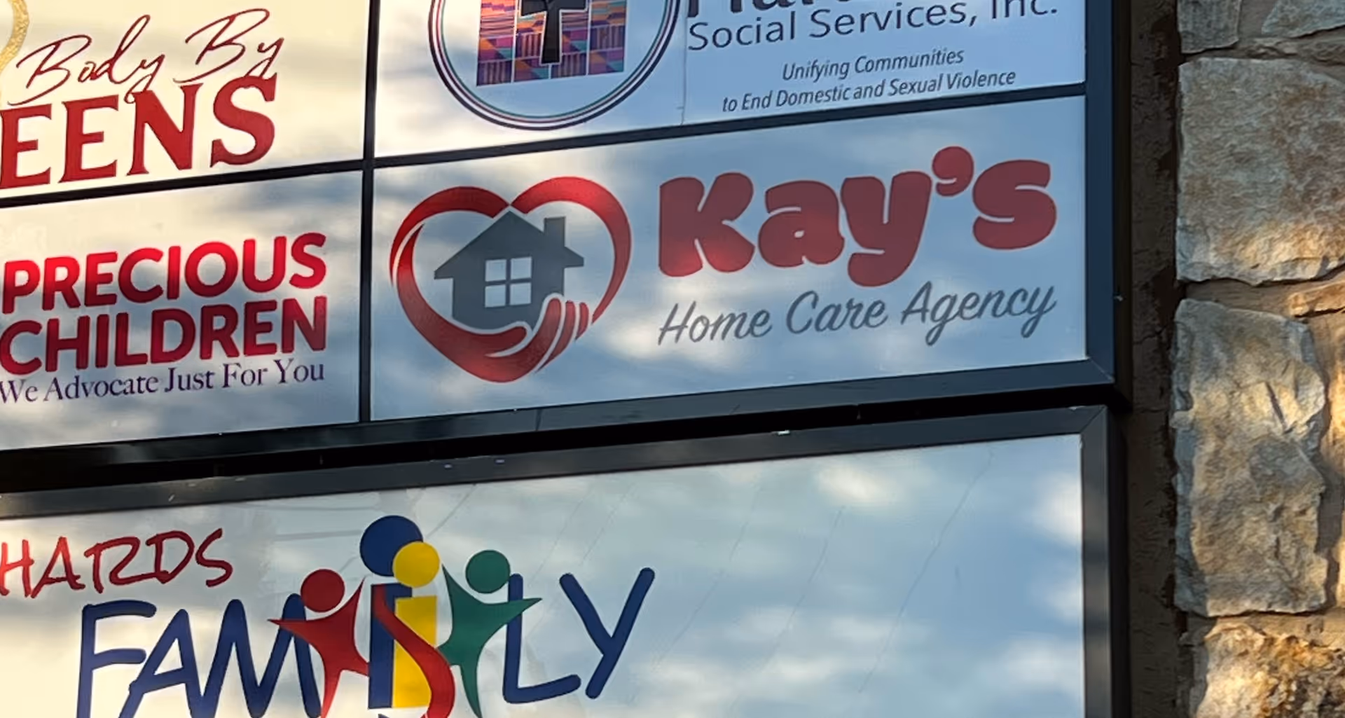 Signage on a building front displaying Kay's Home Care Agency and other logos.