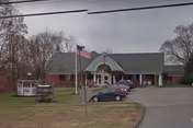 Apple Rehab Colchester building with arched entrance, American flag, and parking lot.