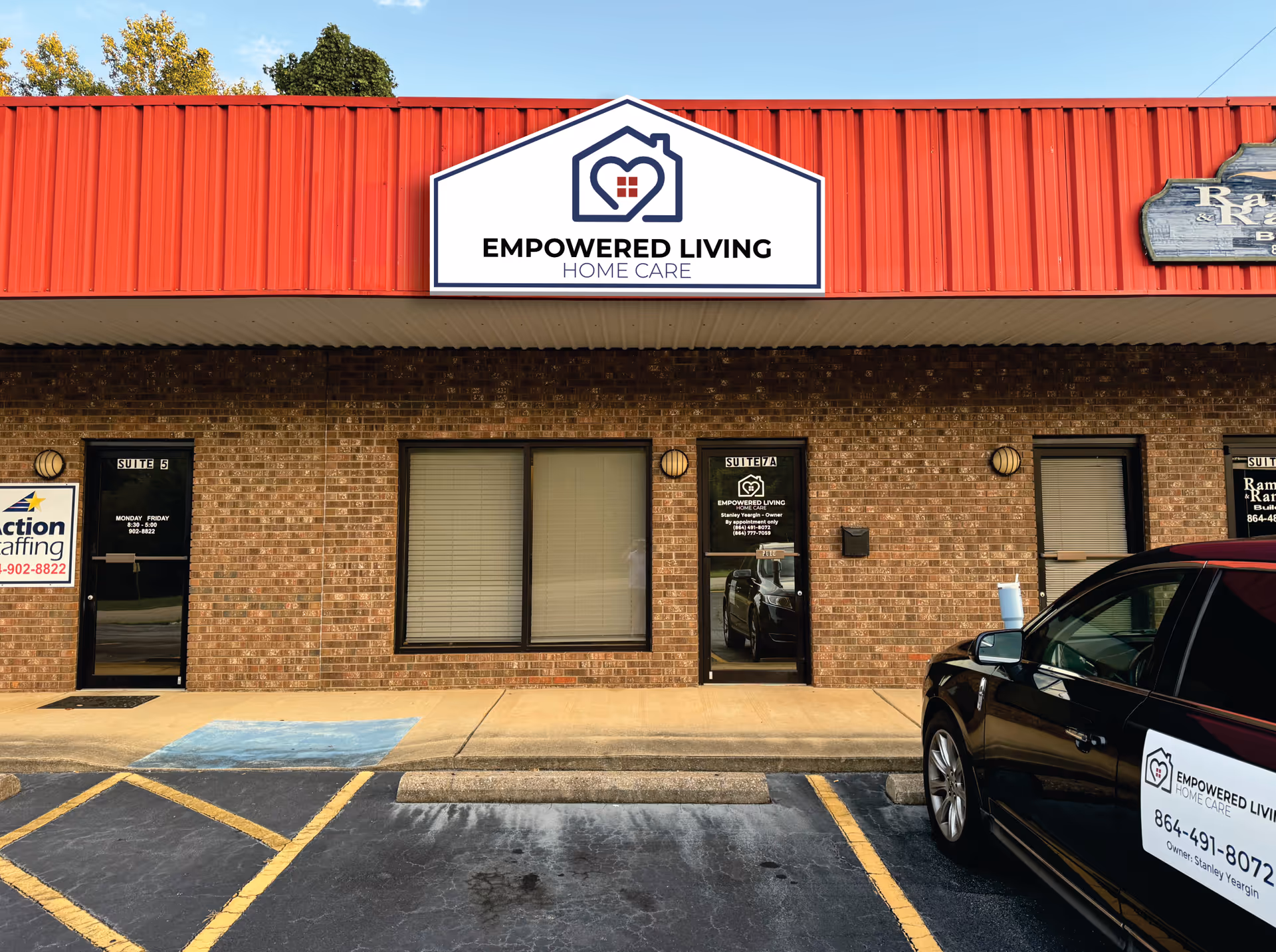 Brick storefront with Empowered Living Home Care sign and a parked car.