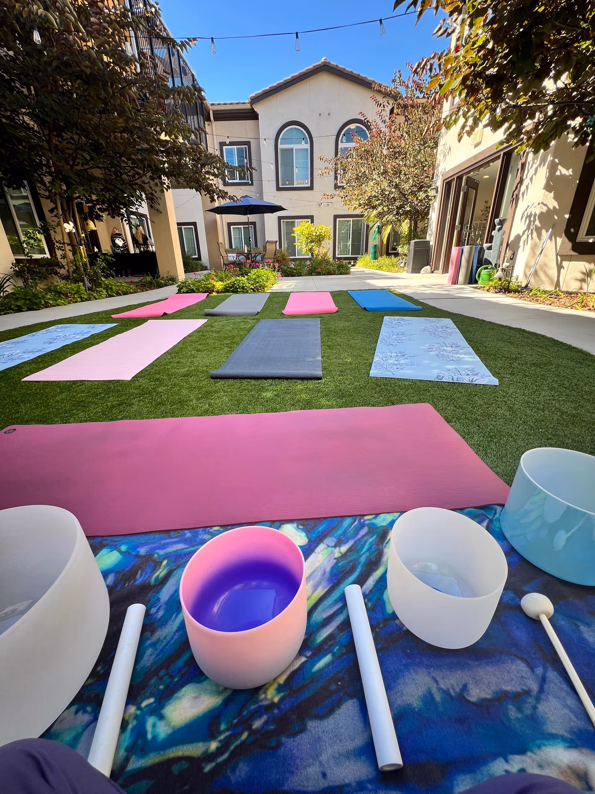 Colorful yoga mats are laid out on a grassy courtyard at Silverado Thousand Oaks.