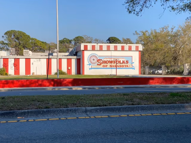 Red-and-white striped building exterior featuring a Showfolks of Sarasota sign.