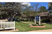 Exterior view of Linn Manor Care Center with front lawn, sign, and trees.