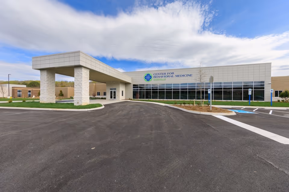 Exterior view of Knoxville Center for Behavioral Medicine building with a covered entrance and parking.