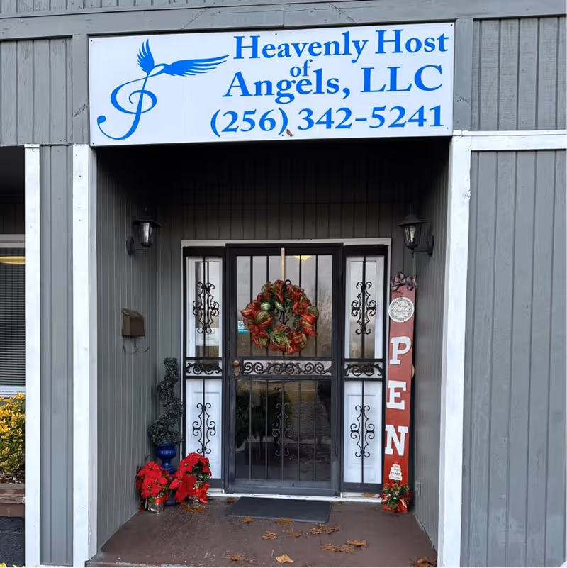 Front entrance of Heavenly Host of Angels, LLC with wreath, wrought-iron gate, and open sign.