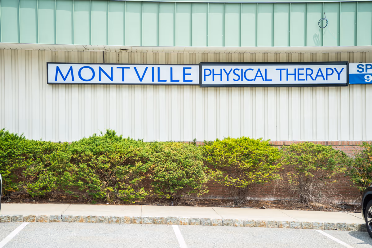 Exterior of a Montville Physical Therapy clinic with a large sign and shrubs.