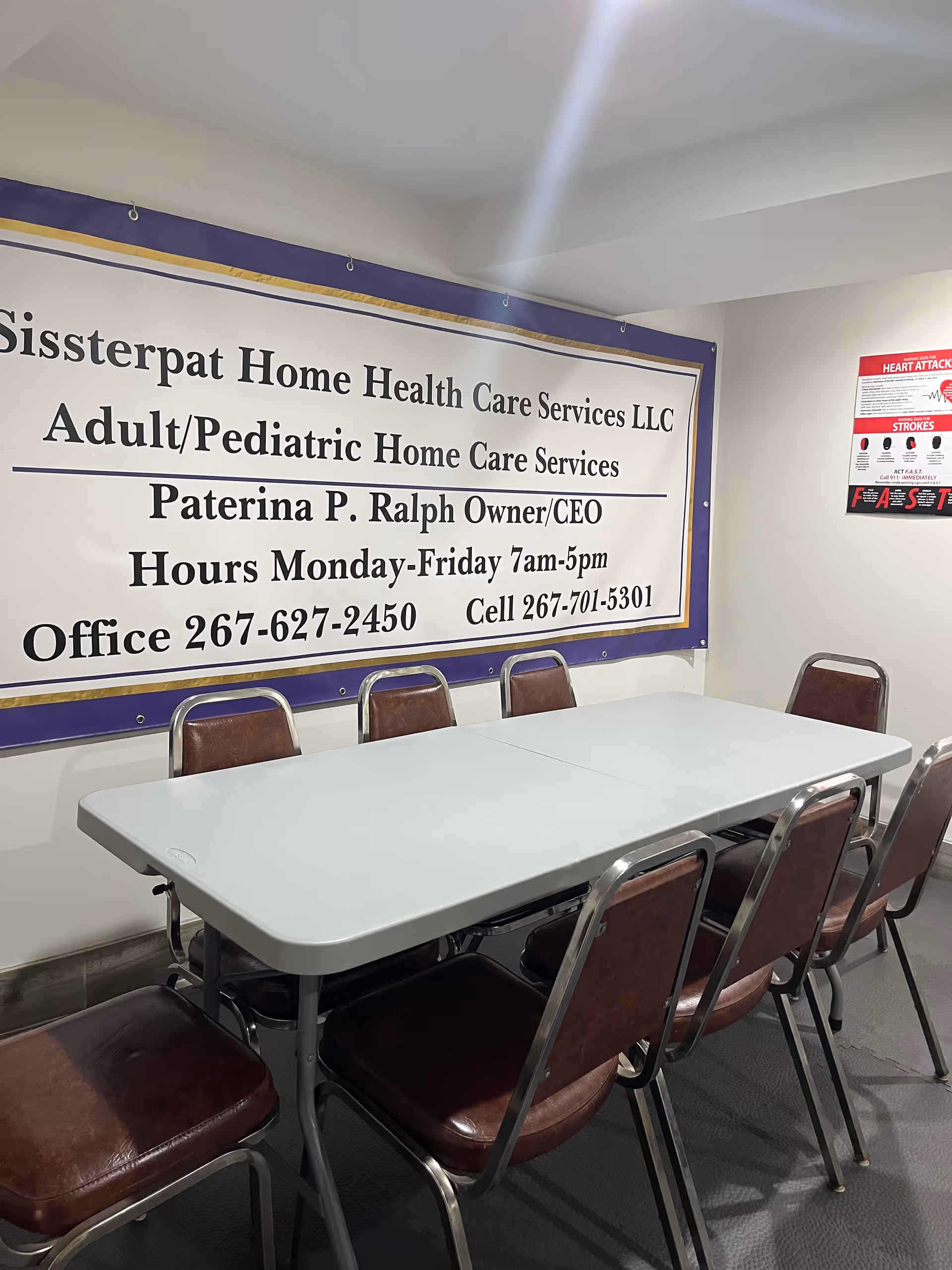 Interior room with a long table and chairs, banner reads Sissterpat Home Health Care Services LLC.