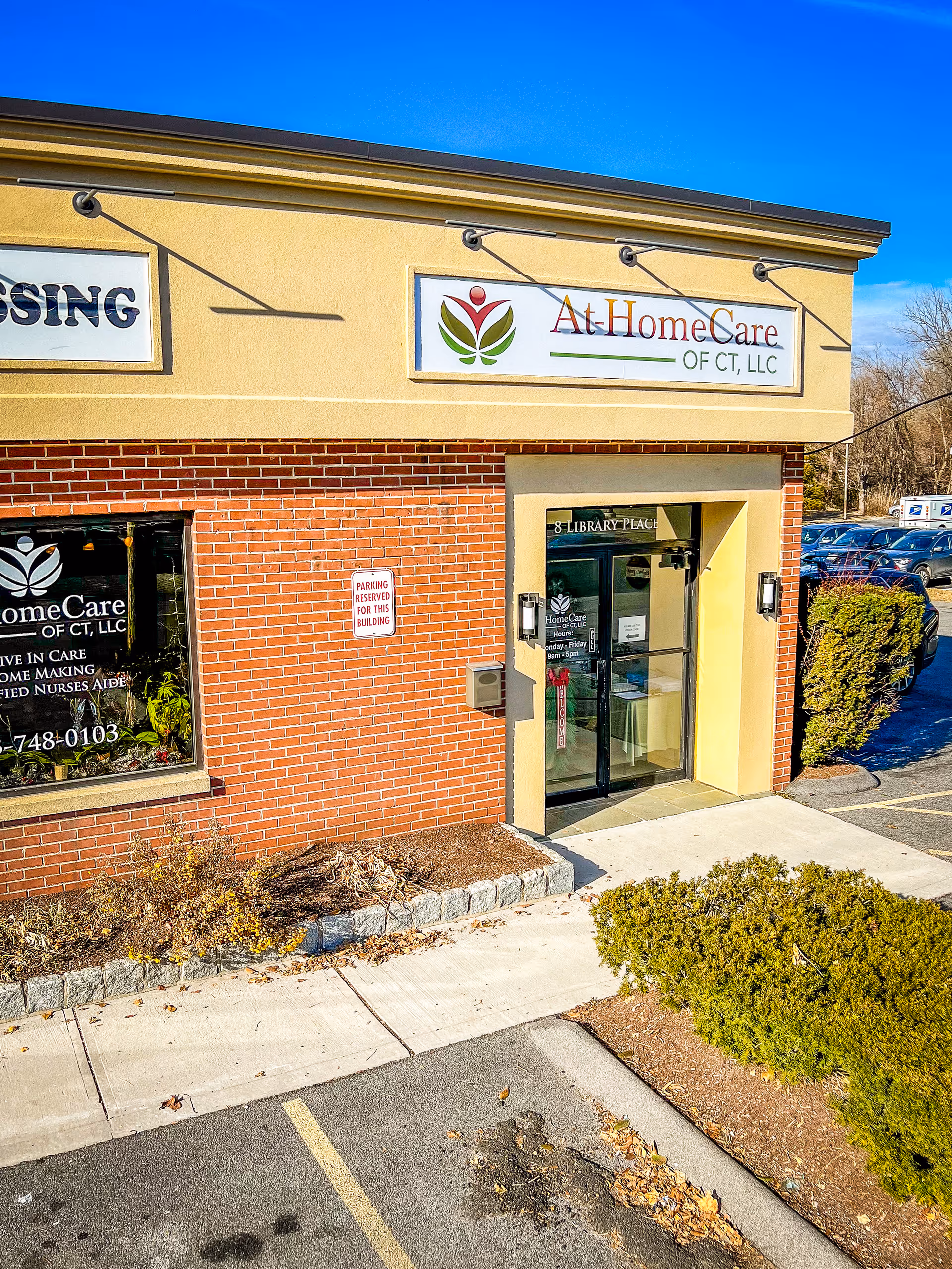 Exterior storefront of At HomeCare of CT, LLC, brick facade and sign above entrance.