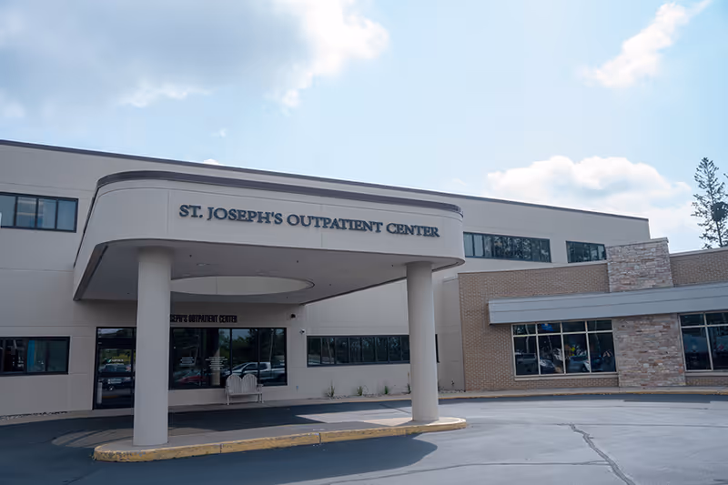 Modern medical center entrance with curved canopy and St. Joseph's Outpatient Center sign.