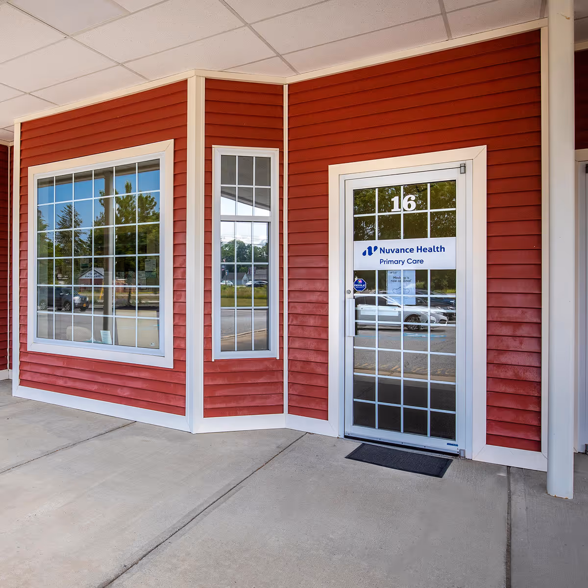Exterior view of a red building entrance with glass door labeled Nuvance Health Primary Care.
