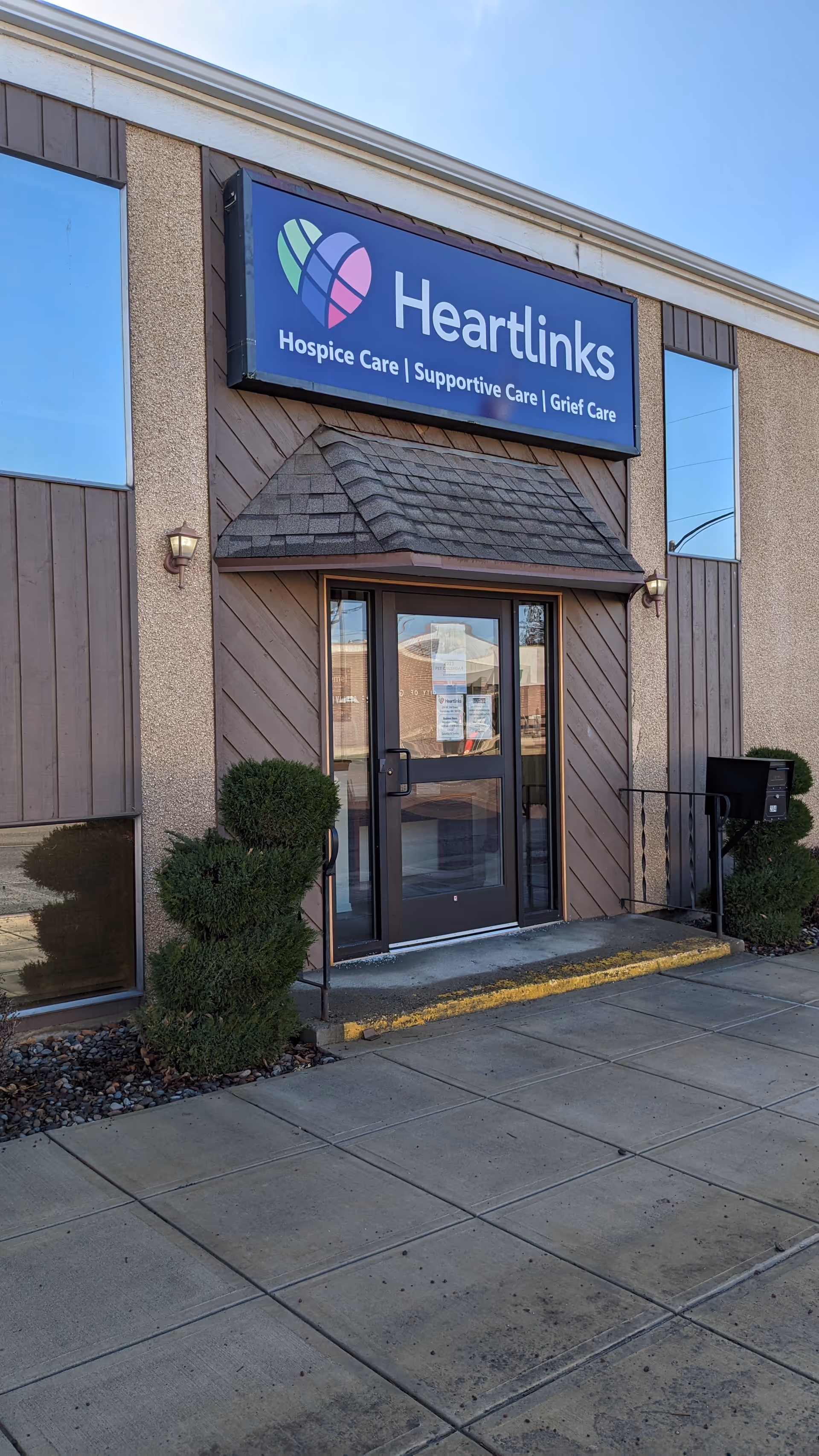 Exterior view of Heartlinks facility entrance with sign, doors, and shrubs