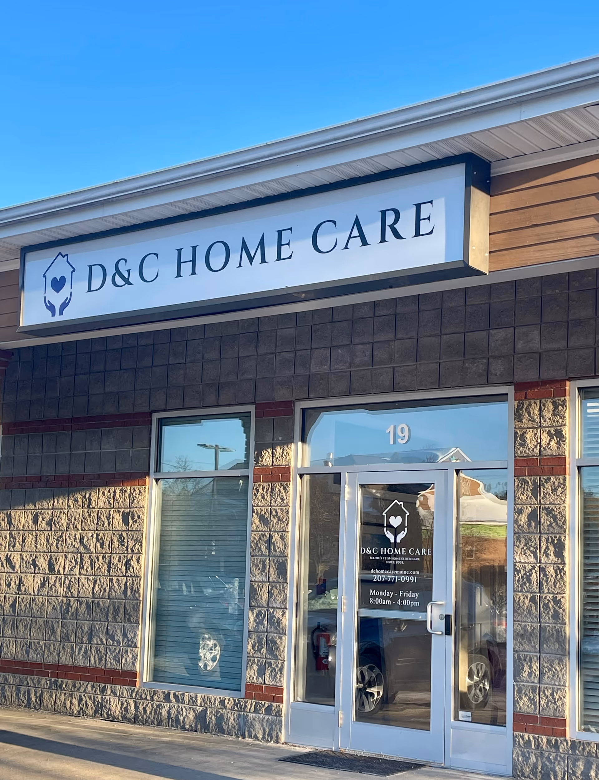 The exterior of a D&C Home Care building with a large sign and glass entrance.