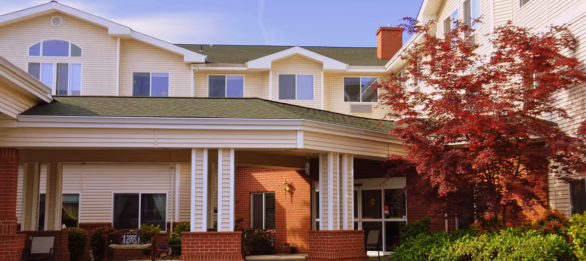 Two-story Avamere at Waterford exterior with brick entry, columns, and red-leaved tree