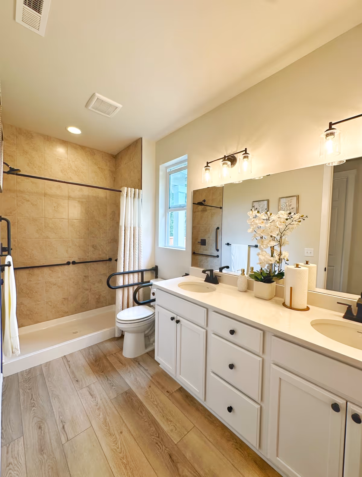 Accessible bathroom with dual sinks, a walk-in tub/shower, and grab bars.