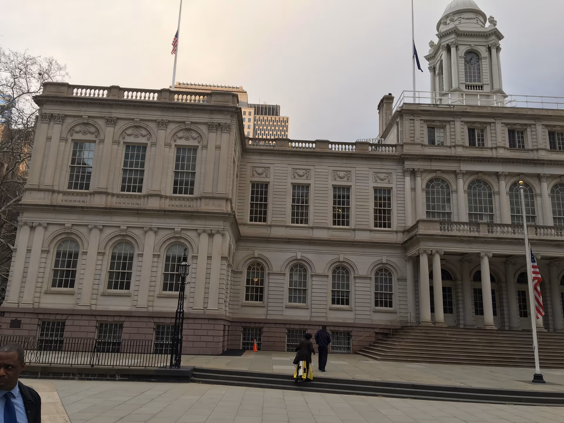 Grand neoclassical building exterior with arched windows, columns, and a clock tower.