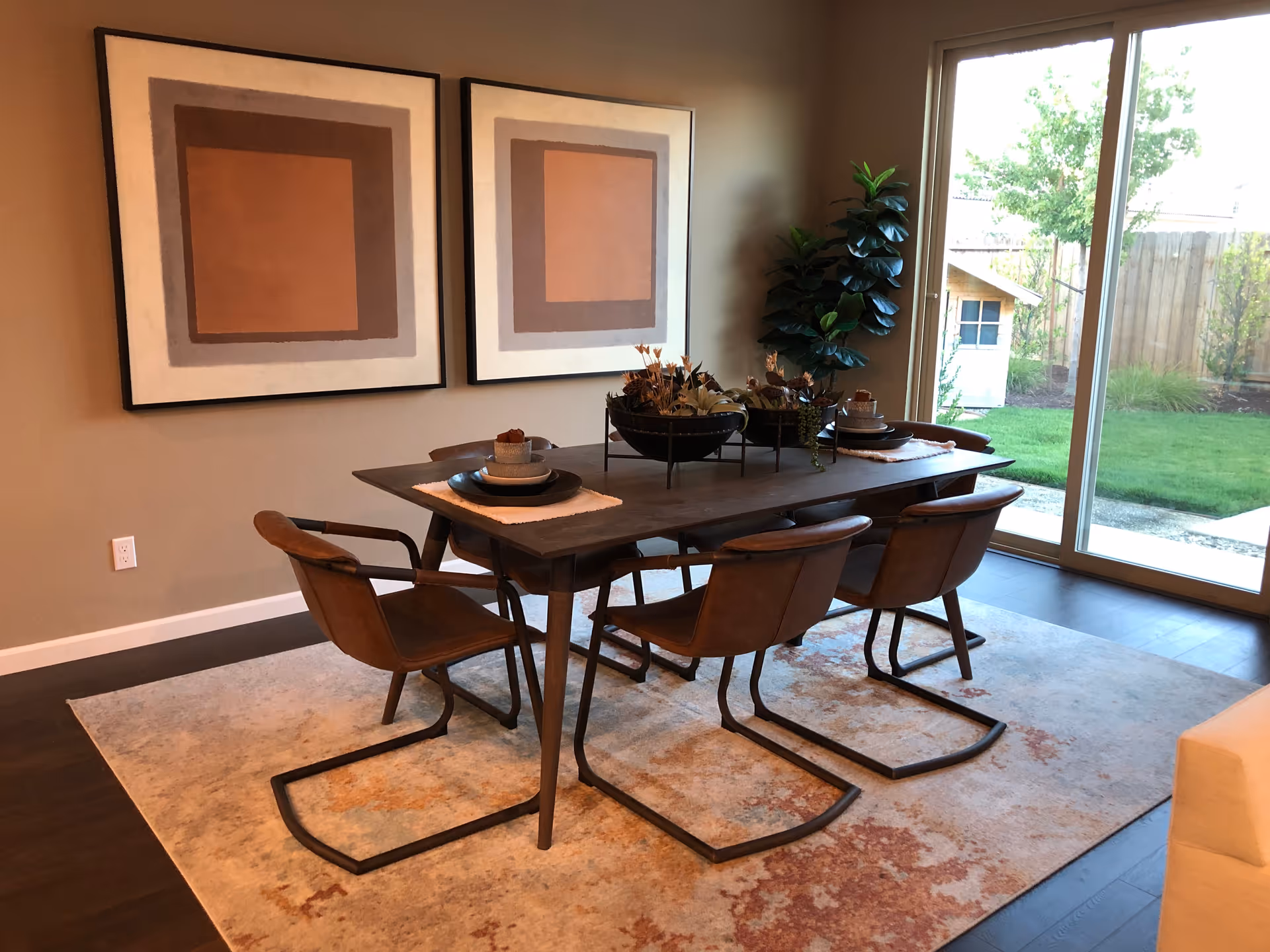 Modern dining room setup with a wooden table, six chairs, and abstract wall art.