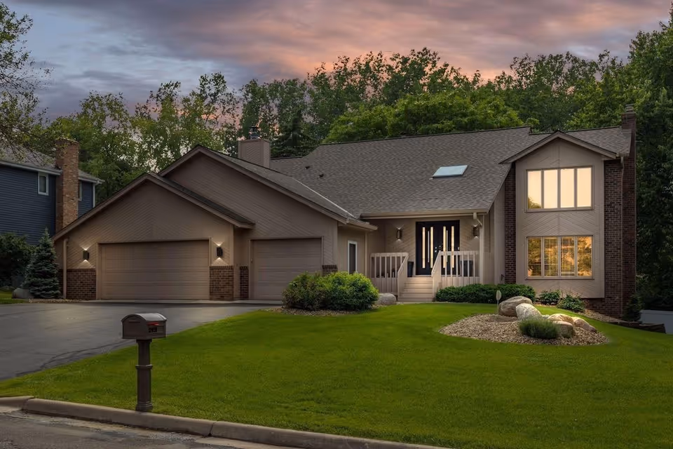 Front exterior of Twin Cities Living Assistance facility with attached garages and landscaped lawn.