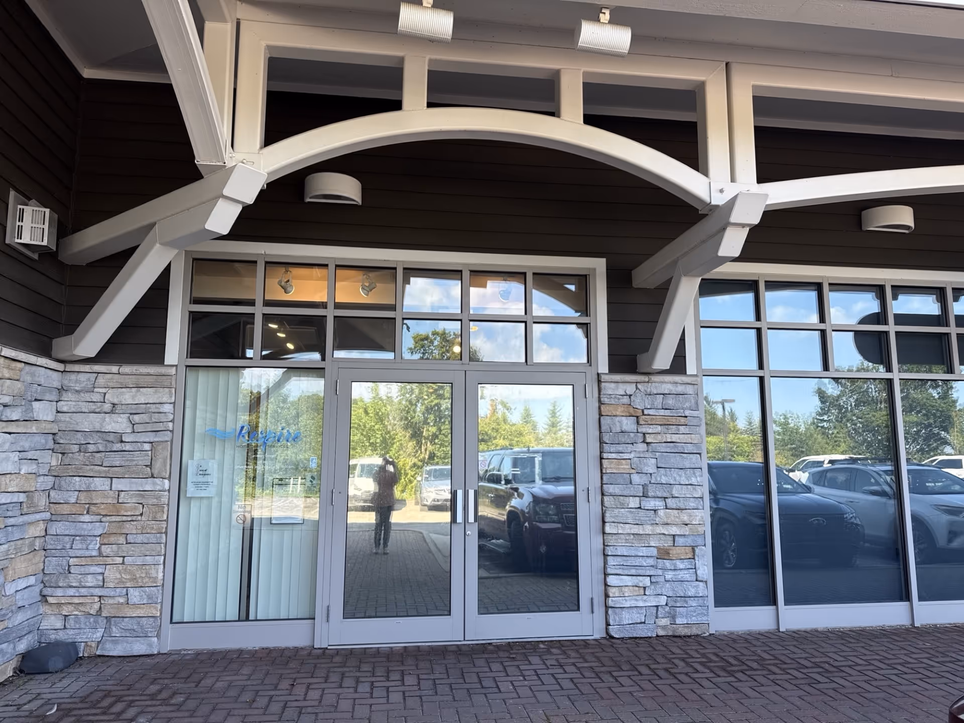 Exterior entrance with glass doors, stone walls, and decorative arches.