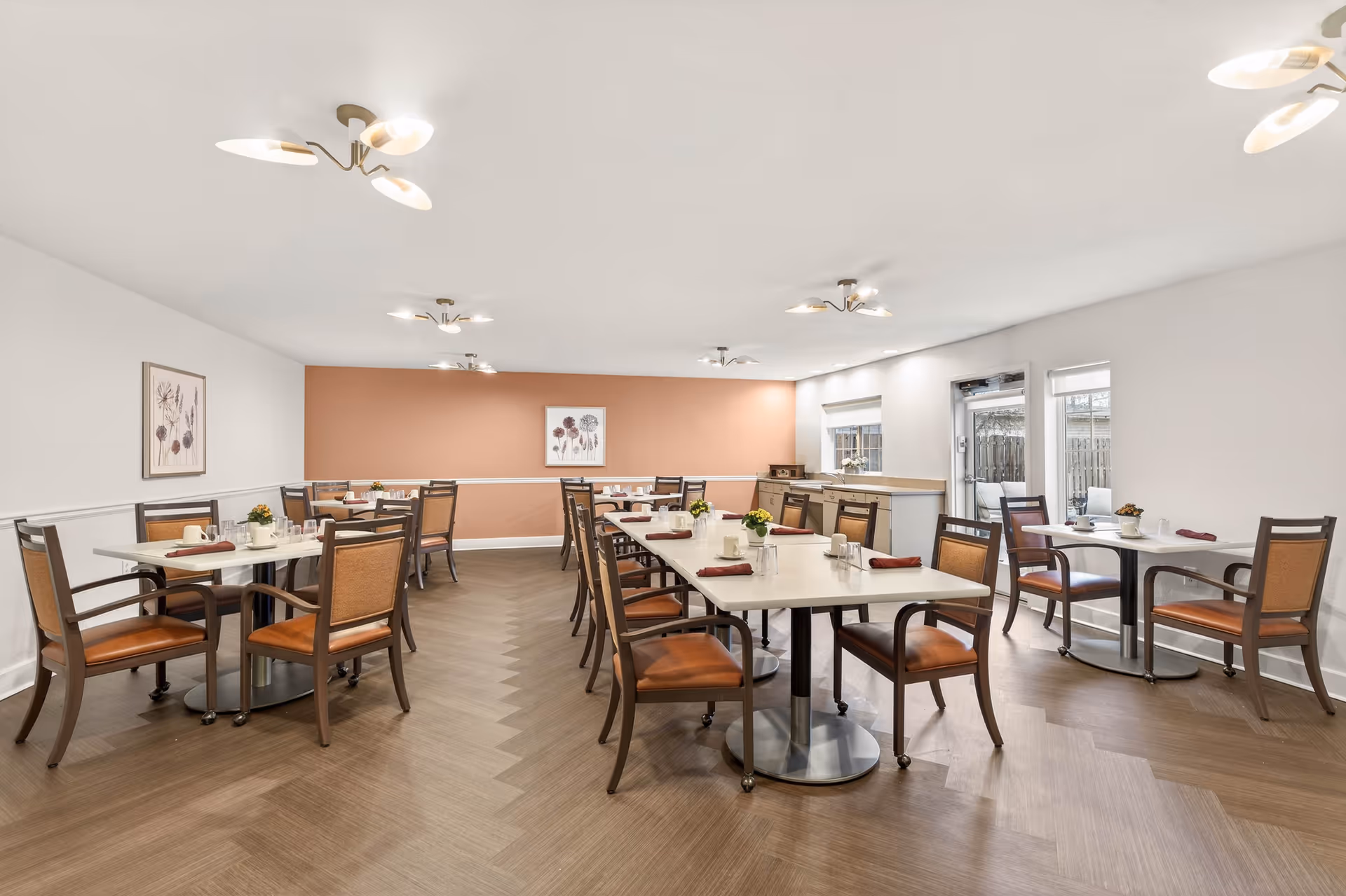 Bright dining room with round tables and warm decor in a senior residence.