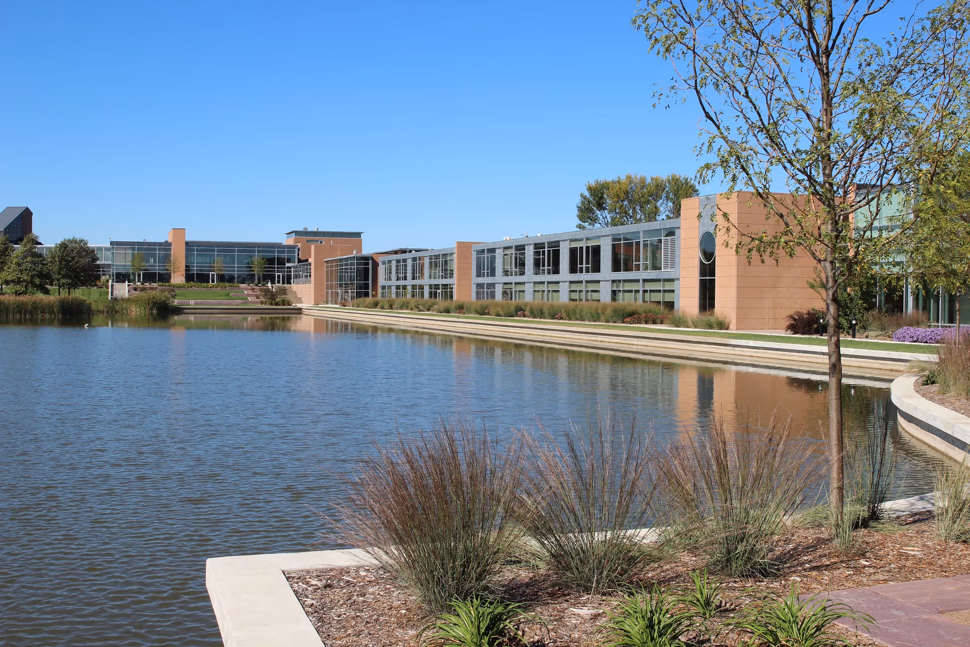 Exterior view of a Good Samaritan Society campus with a pond and modern buildings.