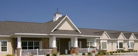 A single-story assisted living facility exterior with a front entry and columns.