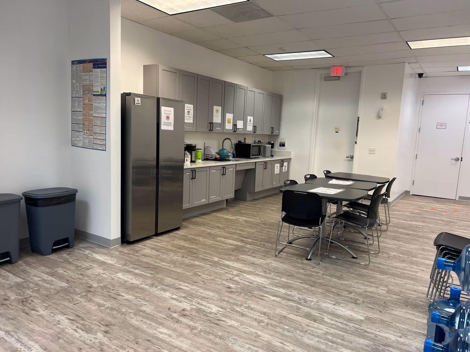 Interior kitchenette with refrigerator, cabinets, and a small dining area.