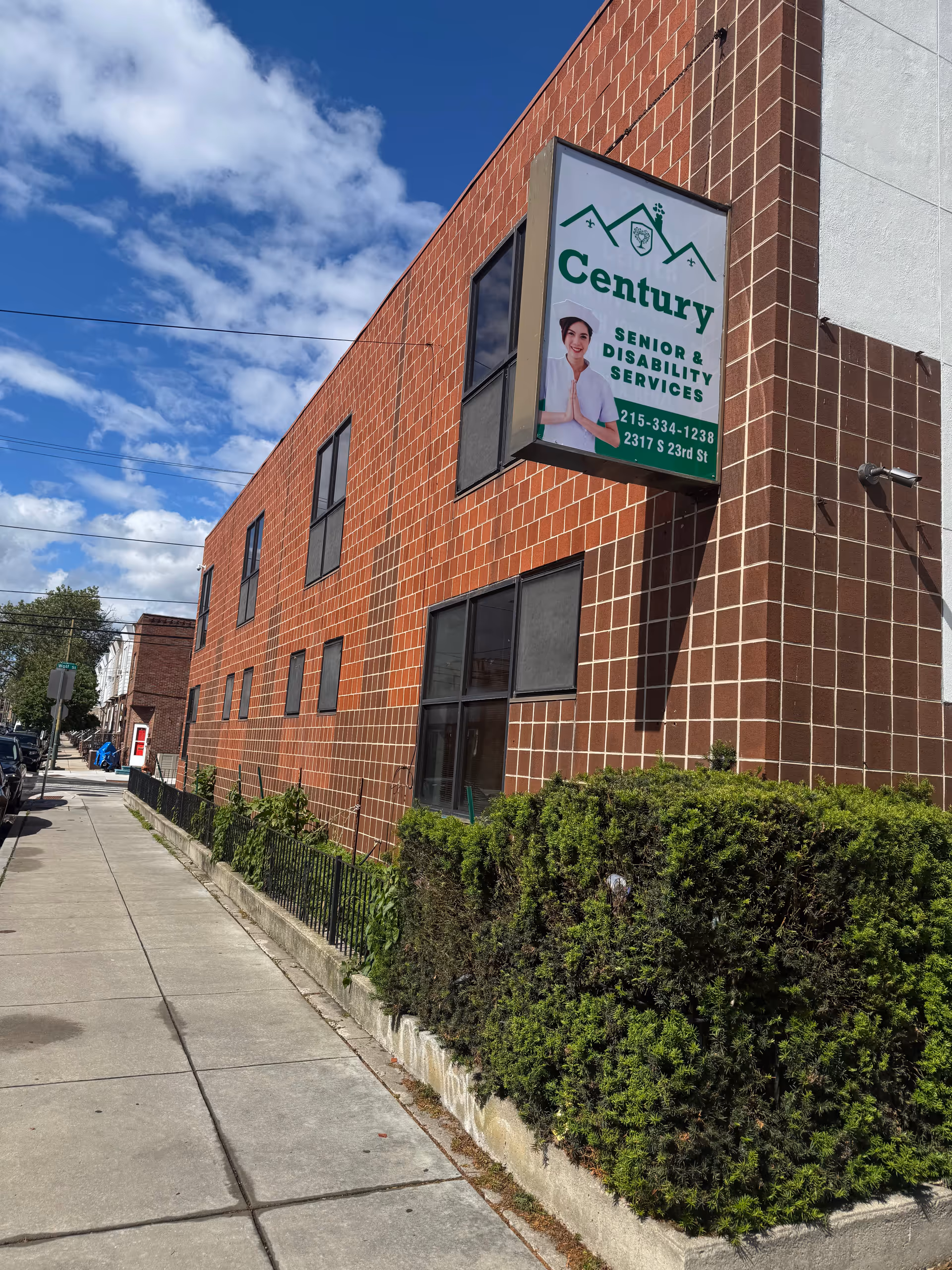 Exterior brick building with a Century sign advertising senior and disability services.