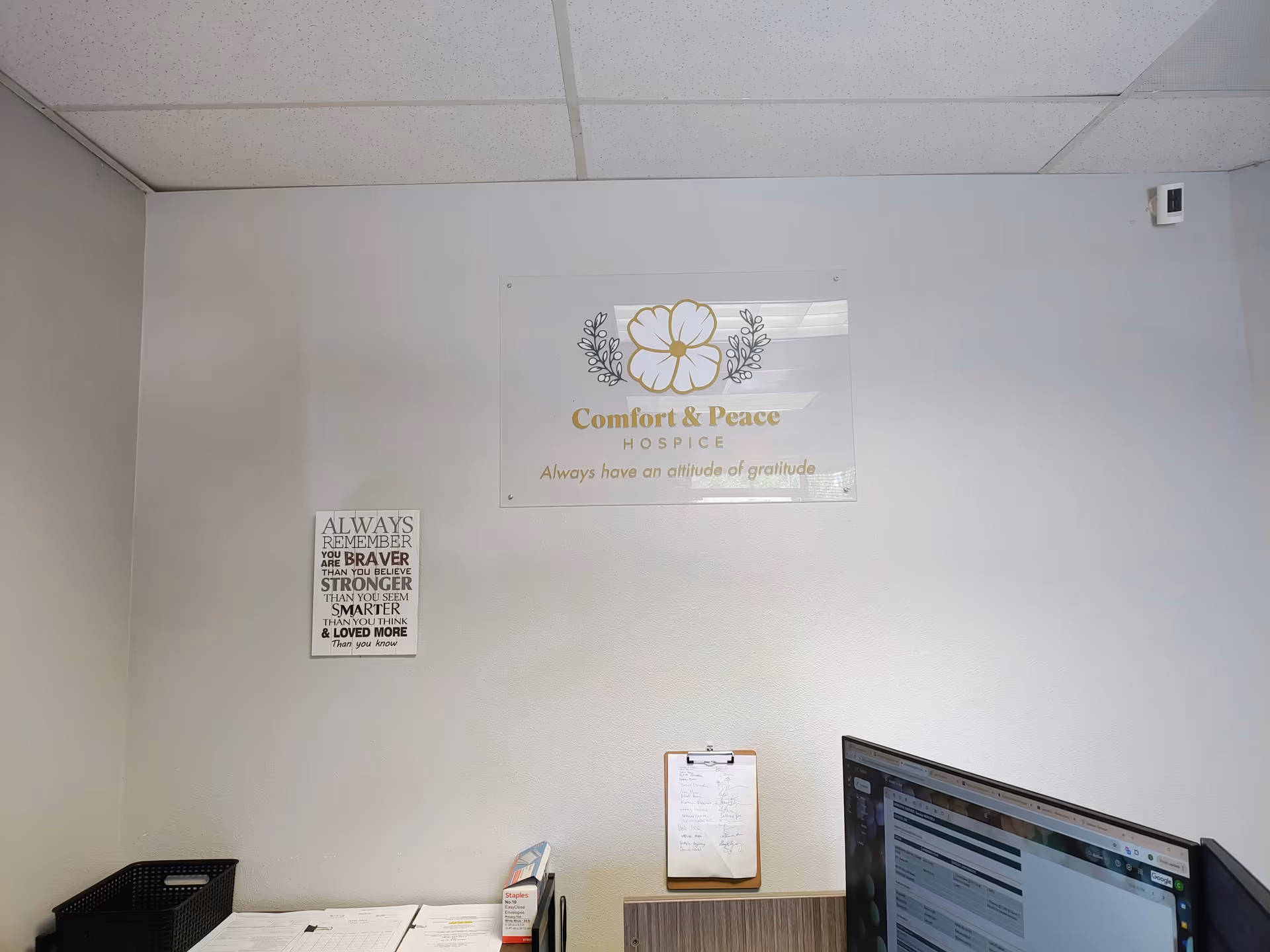 Office corner featuring a Comfort & Peace Hospice sign on the wall.
