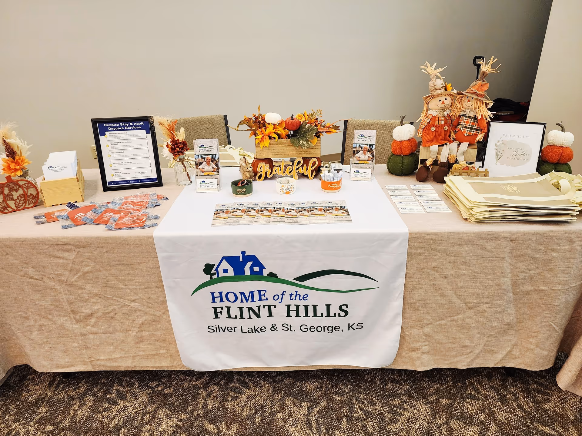 Table display with fall decorations and a Home of the Flint Hills banner.