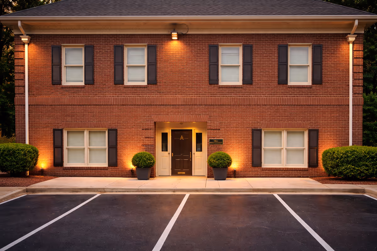Relia home care brick building exterior with symmetrical windows, front entrance, and shrubs.