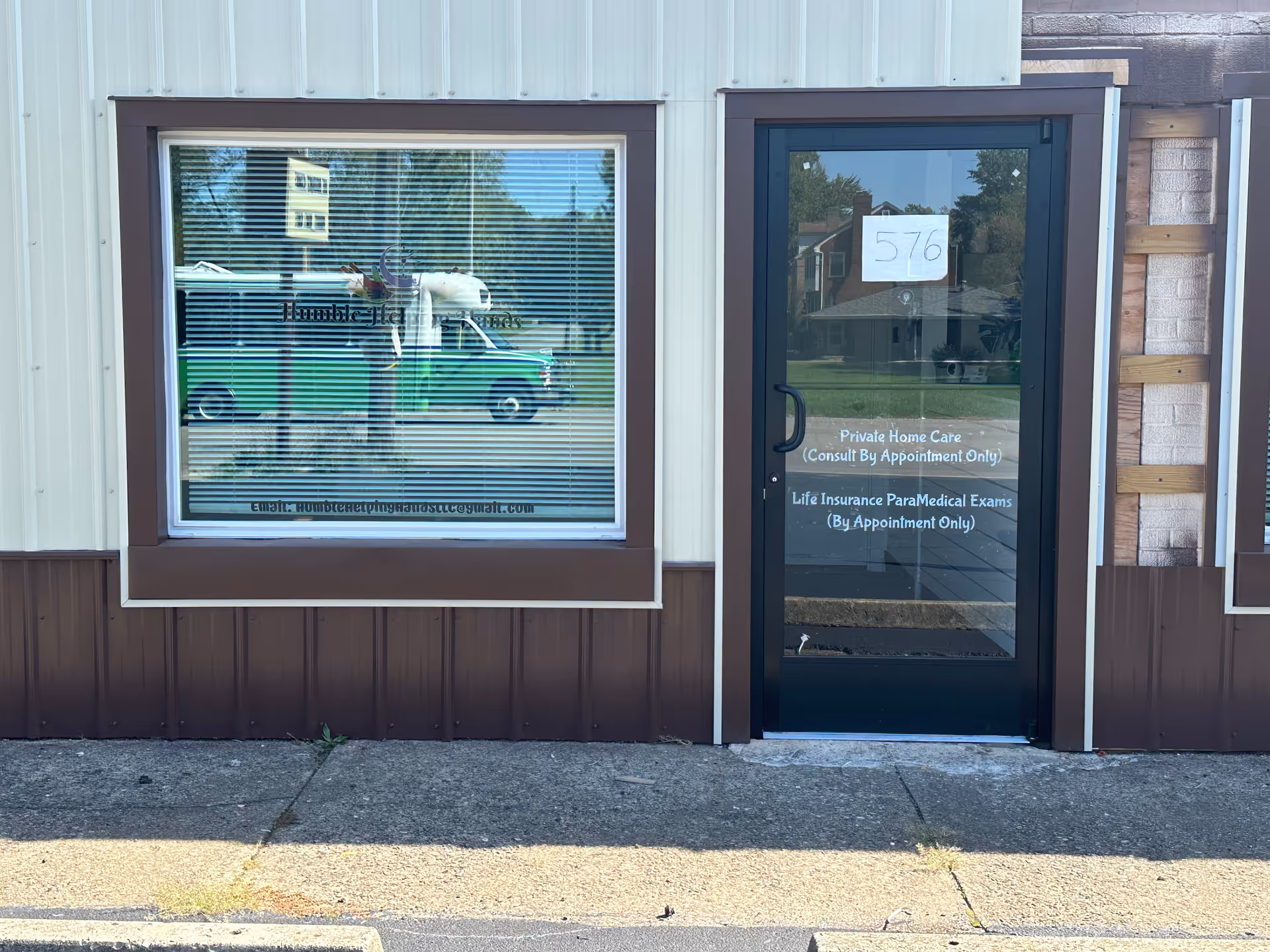 Front view of Humble Helping Hands, LLC building with window sign and glass door.