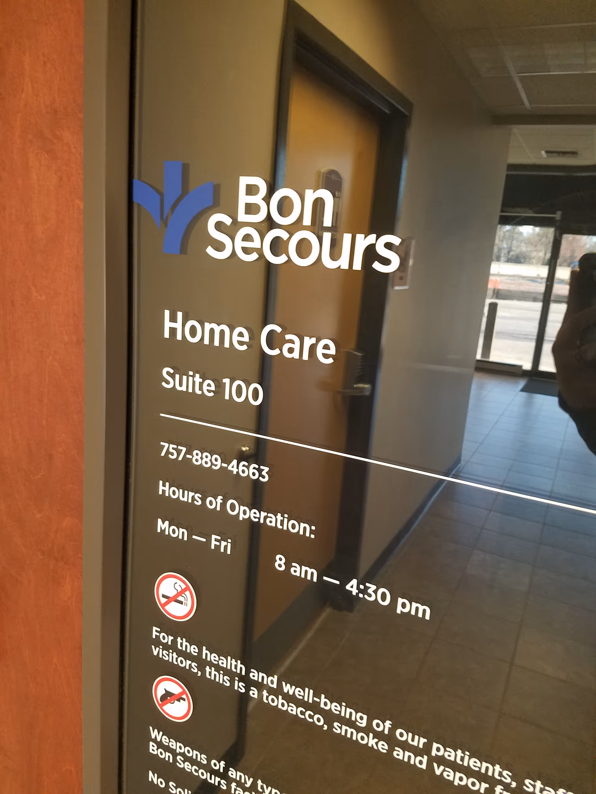 Glass door displays Bon Secours Home Care sign with hallway visible inside.