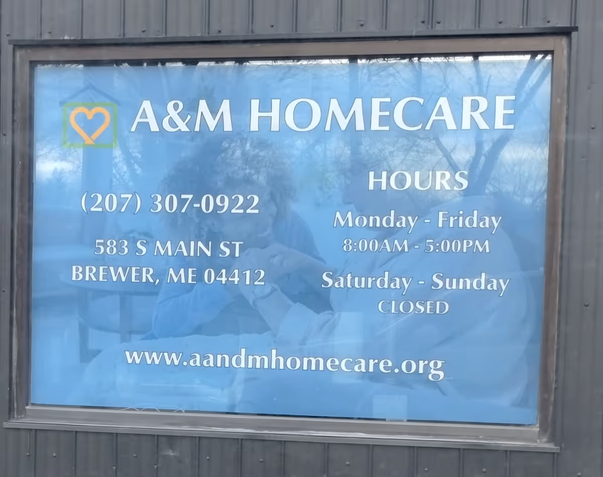 Blue window sign for A&M HomeCare with hours, address, and website.