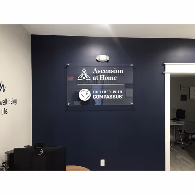 Interior office area with Ascension at Home sign on a navy wall.
